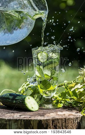 Glass with mineral water with cucumber and mint - home made lemonade