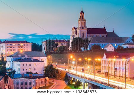 Grodno, Belarus - June 9, 2017: Catholic Church Of The Discovery Of The Holy Cross And Bernardine Monastery At Evening In Night Illuminations Lights. Blue Hour In Hrodna. Sunset Sky