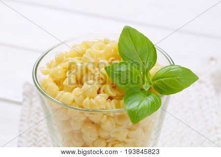 glass of small pasta shells on white table mat