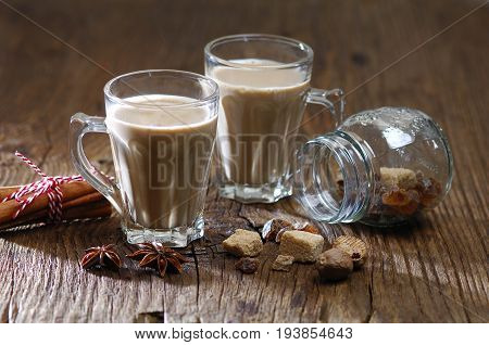 masala tea, cinnamon sticks, brown sugar, star anise on rustic background