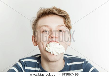 Boy Goofing Off As His Mouth Is Stuffed With Creme