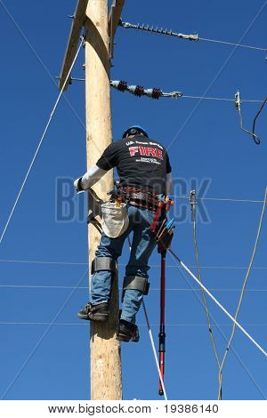 an electrical lineman student working on a pole at a lineman college