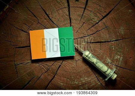 Ivory Coast Flag On A Stump With Syringe Injecting Money In Flag