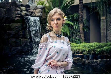 Woman is posing in a tropical garden of Bali island.