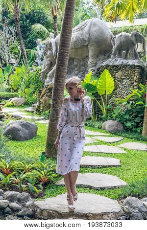 Woman walking in a tropical garden of Bali island.