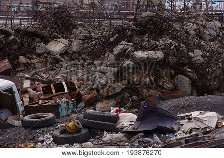garbage dump of concrete and metal waste old car tires and car parts