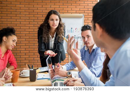 Businesswoman as a meeting leader asking her colleague for an opinion while making a presentation