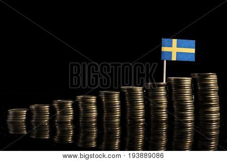 Swedish Flag With Lot Of Coins Isolated On Black Background