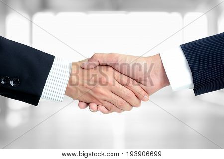 Handshake of businessmen on white room background - greeting dealing merger and a acquisition concepts