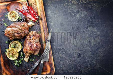 Barbecue Leg of Lamb with Tomato Chili Relish as top view on burnt cutting board 