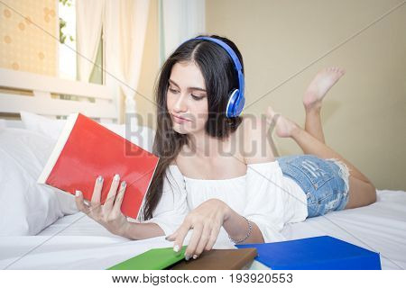 Beautiful Young Woman Looking And Holding Book On The Bed, Woman Education Concept, 20-30 Year Old.