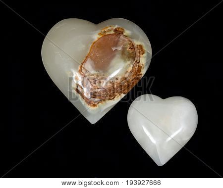 Polished multicolor carved onyx hearts on black background