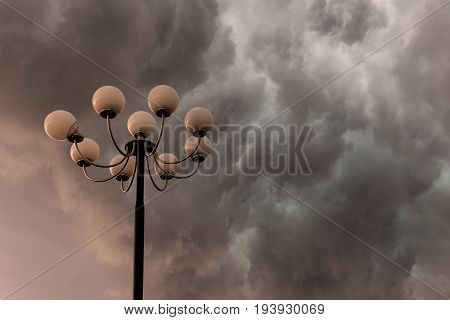 Lightning flashes stormy clouds over big glorious street lamp