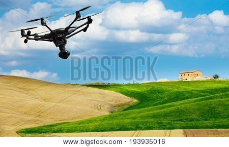 A flying drone with camera with blured hills of Tuscany in the background
