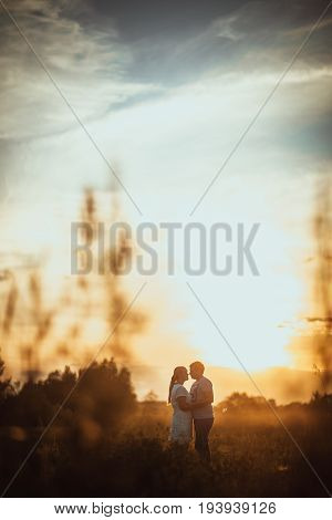 love story man and woman on the background of haystacks and sun.