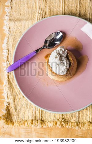 Flan - A Sweet Custard Creme Caramel With Creme On Top, On A Pink Plate Over A Wooden Board.