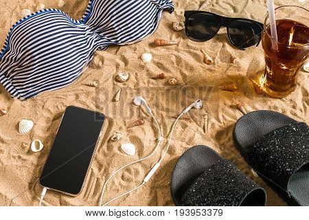 Summer bikini and accessories stylish beach set, Beach bikini summer outfit and sea sand as background, Top View, Concept. Copy space. Still life mockup flat lay