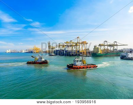 Logistic conceptTug boat support and out of the harbor. The ship's cargo containers