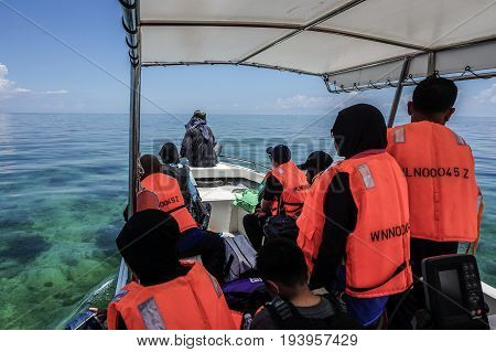 Labuan,Malaysia-May 1,2017:Group of people on the boat visiting to the Rusukan Besar island in Labuan,Malaysia.It is very popular place for tourist to visit & snorkeling underwater in Labuan.