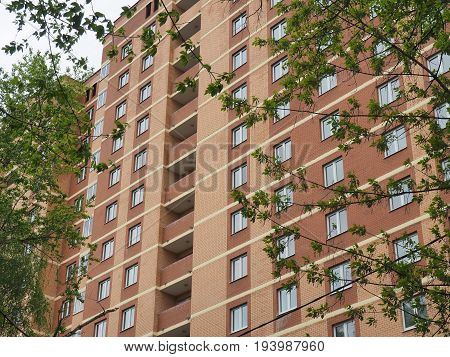 Facade of the new multi-storey building of brown brick