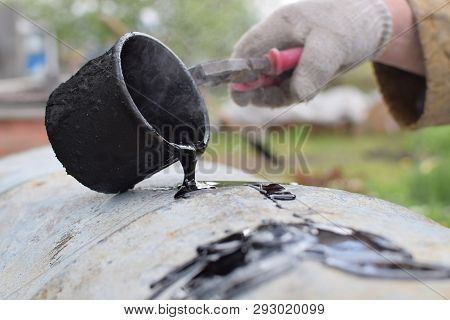 Drop Of Tar From Metal Cup On White Surface At Heavy Industry