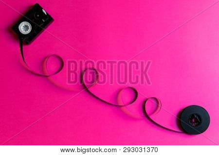 Retro Film For Old Video Camera On Al Pink Paper Backgound, Abstract Creative Concept. Retro 80s. Mi