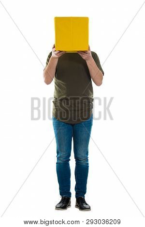 Full Length Portrait Of Casual Incognito Young Man Holding A Yellow Box Instead Head Isolated Over W