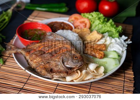 Fried pomfret fish and rice, popular traditional Malay or Indonesian local food.