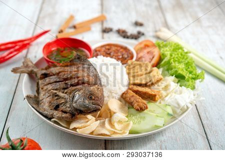Fried pomfret fish and rice, popular traditional Malay or Indonesian local food.