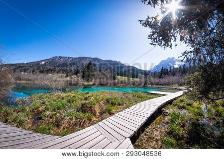 Lake Zelenci, Source Of The Sava Dolinka River, With The Observation Trail Footbridge And Ponce Moun