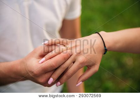 Man Makes A Marrige Proposal To A Girl. Gives Her A Ring For The Engagement. Close-up Hands