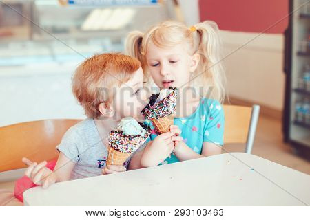 Lifestyle Portrait Of Two Happy Caucasian Cute Adorable Funny Children Girls Sitting Together Sharin