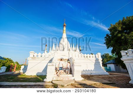 Kids brother and sister visiting white stupas of ancient Maha Aung Mye Bonzan Monastery one of the most beautiful landmarks of Royal City of Inwa in Myanmar