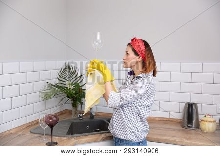 Woman Cleaning Or Ruges Glass In The Kitchen.