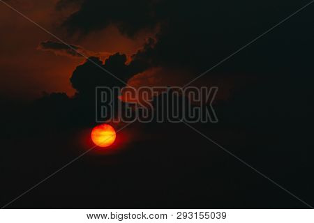 Red Big Sun In Dark Clouds. Devil Sunset. Horror View Of Sun In Black Clouds Sky. Summer Sunset. Fie
