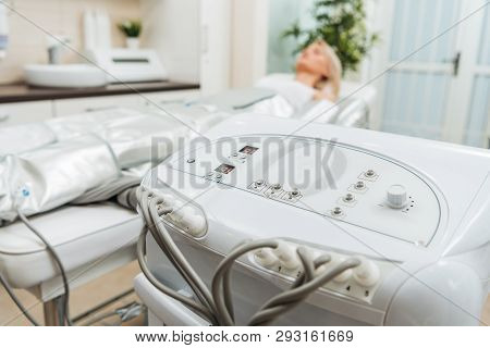 Girl On Beauty Couch And Pressotherapy Apparatus In Clinic