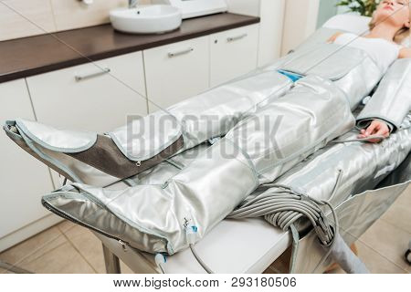 Selective Focus On Woman Lying On Beauty Couch During Pressotherapy Session