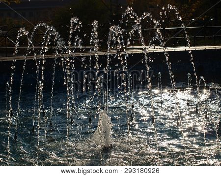 Streams Of Fountain Like Beads Glow In The Rays Of The Setting Sun On A Summer Evening In The City P