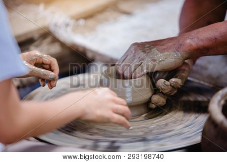 Making It Together. Close-up To Hands Of Potter Teacher And Child