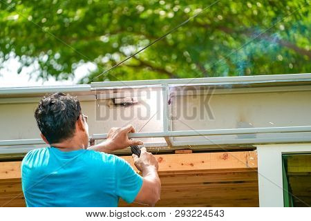 Asian Worker Welds The Steel Stick To Create A Structure For Roof Water Drain., Home Improvements An