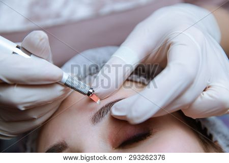 Permanent Makeup For Eyebrows. Microblading Brow. Beautician Doing Eyebrow Tattooing For Female Face