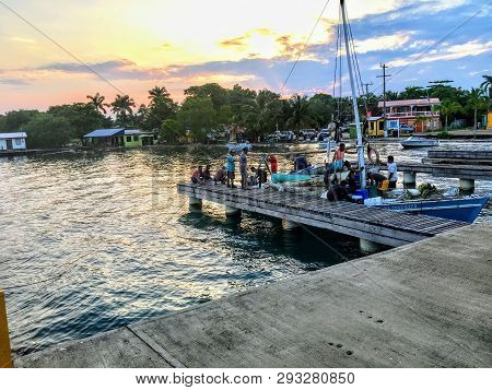 Placencia, Belize - May 27th, 2018: A Group Of Local Belizean Fisherman Return Their Boat To The Doc