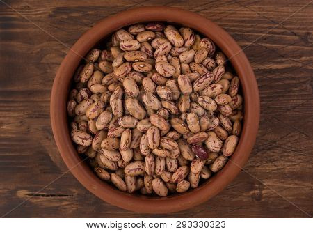 A Plate Of Beans On Wooden Table Background