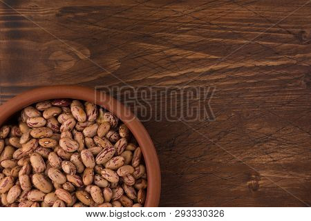 A Plate Of Beans On Wooden Table Background