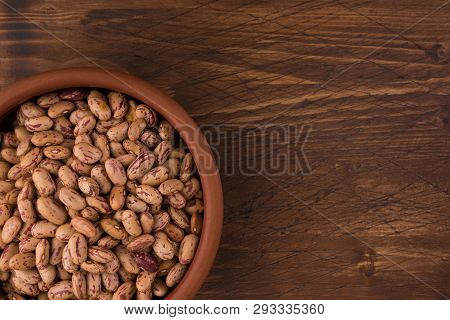 A Plate Of Beans On Wooden Table Background
