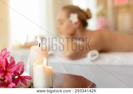 Beautiful Candles On Wood Table In Spa Room With Beautiful Woman At Spa Salon Background. Charming B