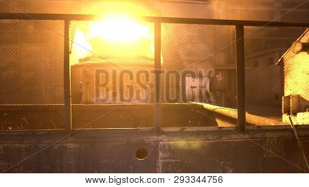 Metal Steel Worker In Special Uniform Passing Through Metallurgical Shops With Bif Metal Furnace. St