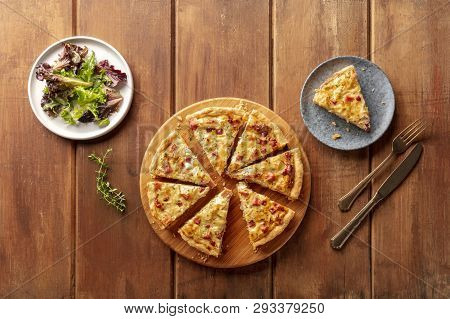 A Photo Of A Quiche With Mesclun Salad Leaves, Shot From The Top On A Dark Rustic Wooden Background 