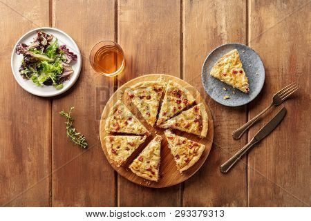 A Photo Of A Quiche With Wine And Mesclun Salad Leaves, Shot From Above On A Dark Rustic Wooden Back
