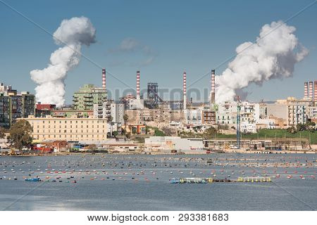 White Smoke Going Up From The Chimney Of Steel Plant Of  Taranto, Puglia. Italy